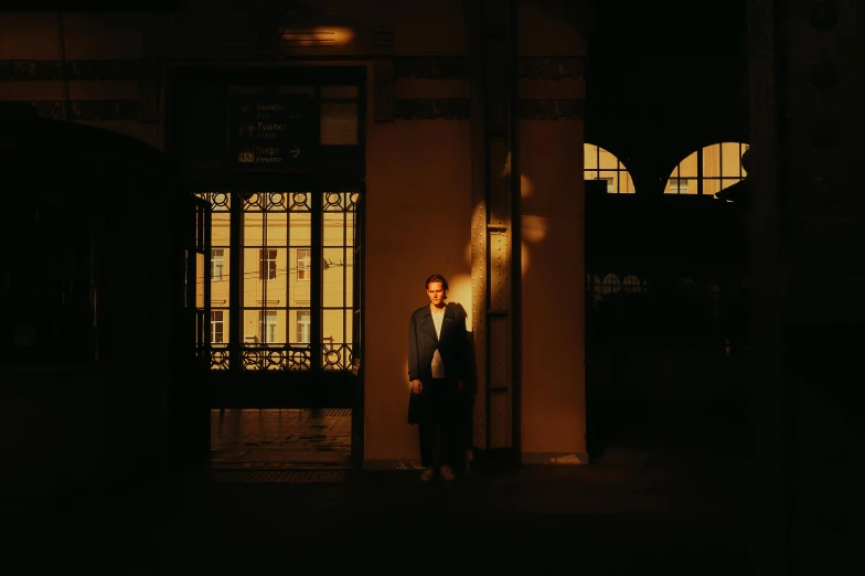 a man stands outside the entrance to a building