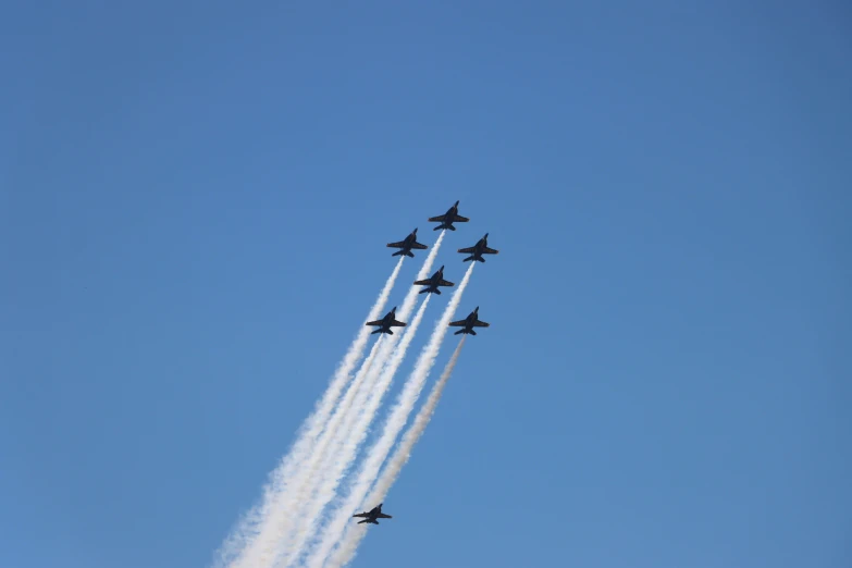 several planes in the sky performing stunts