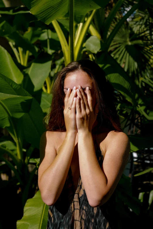 a woman covers her eyes with her hands