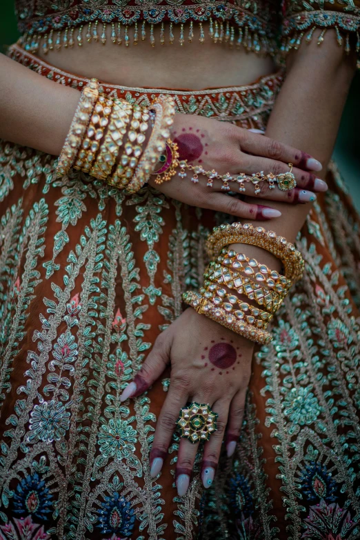 a close up of the arms and hands of two women wearing jewelry