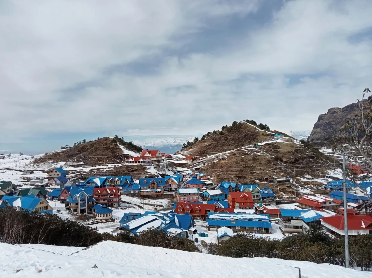 the small village is nestled between the snow covered mountains