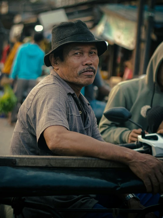 two men riding motorcycles down a street with others in the background