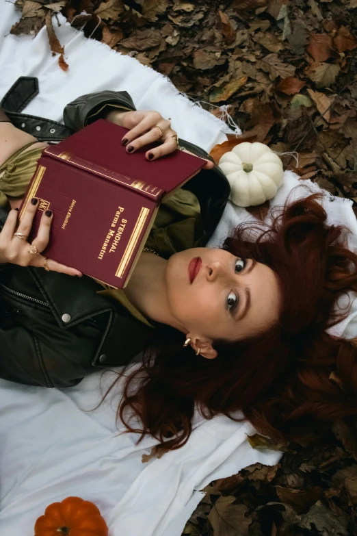 a woman laying down on top of leaves