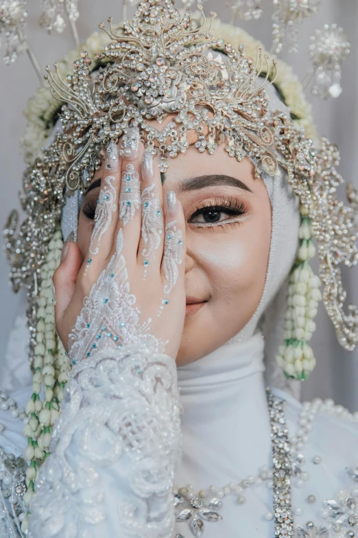 an asian woman wearing white has her eyes closed