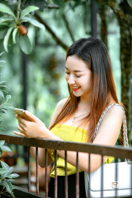 a woman looking at her cell phone while standing outside