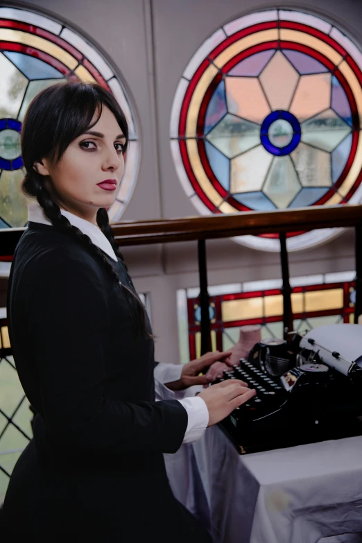 a lady sitting at a table with a typewriter