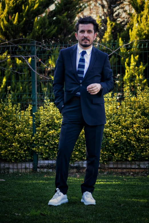 a man in a suit standing on grass