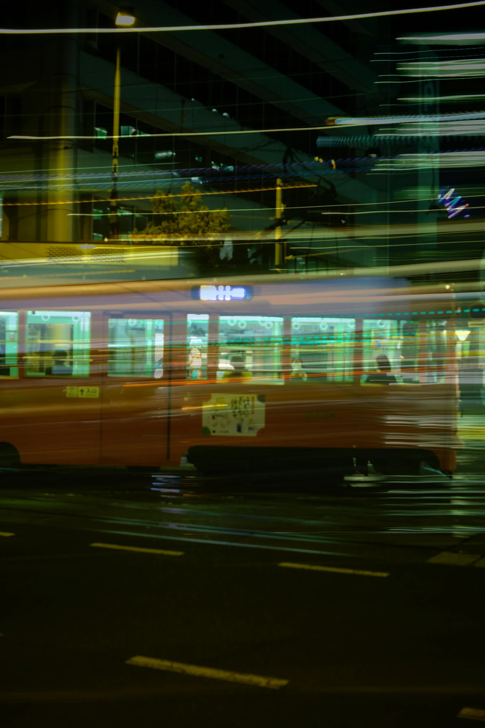 a red bus driving down a street with a traffic light in the background