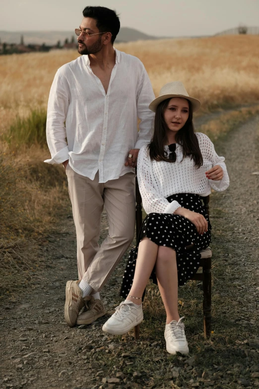 a man and a woman sitting in a chair in the middle of the road