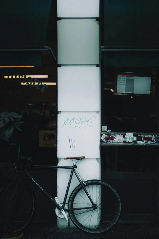 a bicycle sits leaning against a white structure