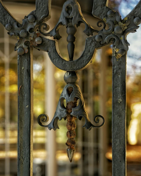 an ornate iron work has a small red flower attached to it