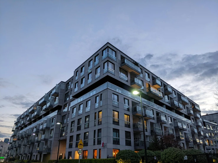 a tall building sitting in the middle of a park at dusk