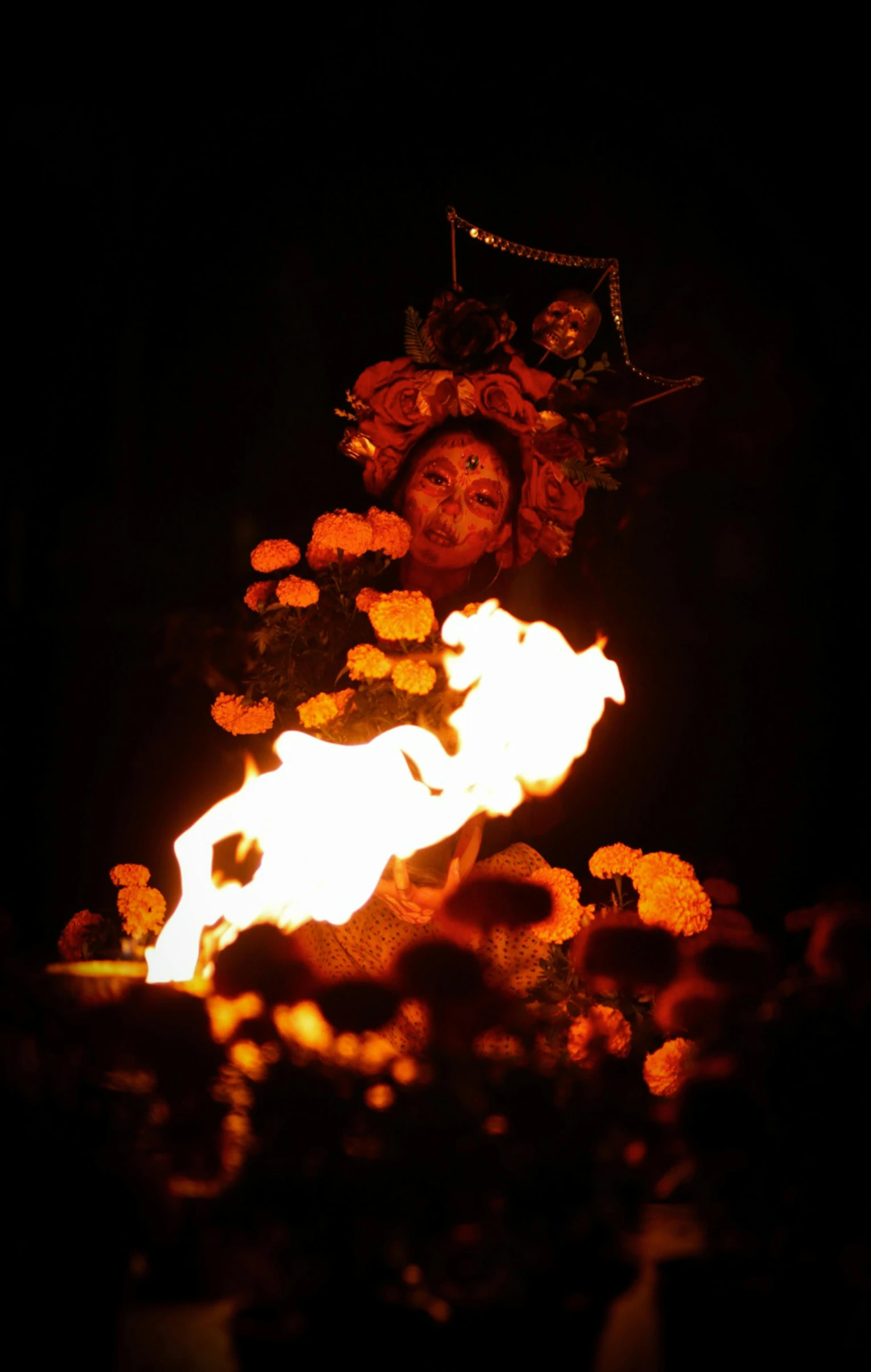 a woman is standing near some fire with roses