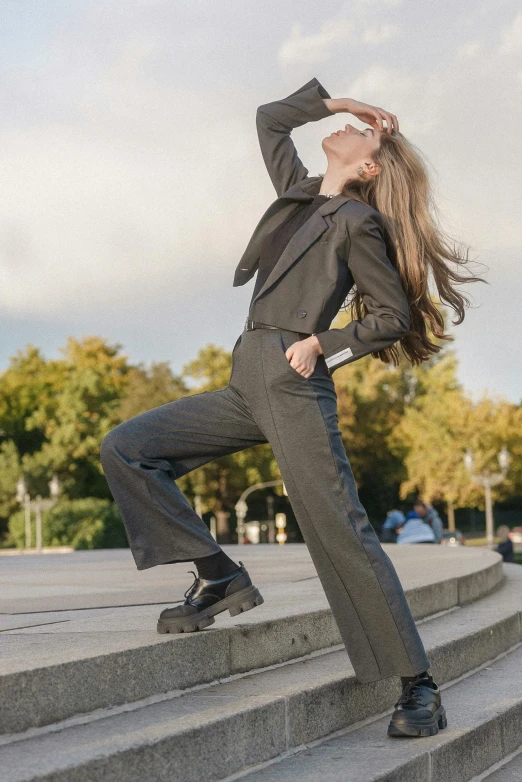 a woman in a black shirt and gray suit posing for the camera