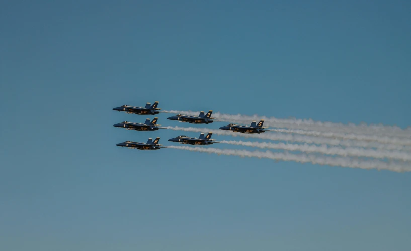 nine black fighter jets are flying together in formation