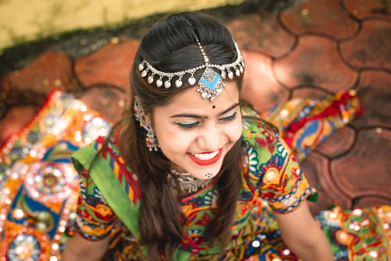 a girl in bright indian clothing smiles at the camera