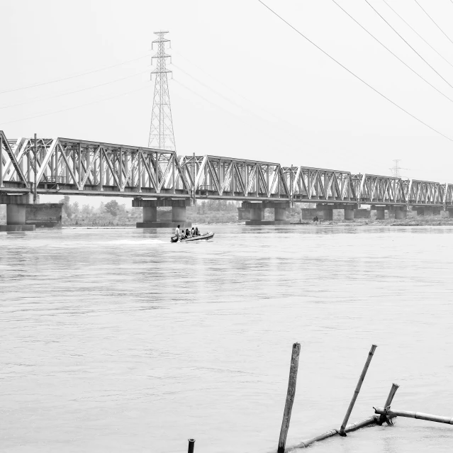 a man in a boat glides under the bridge