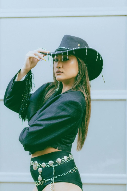 a woman in a cowboy hat and skirt holding a cigarette