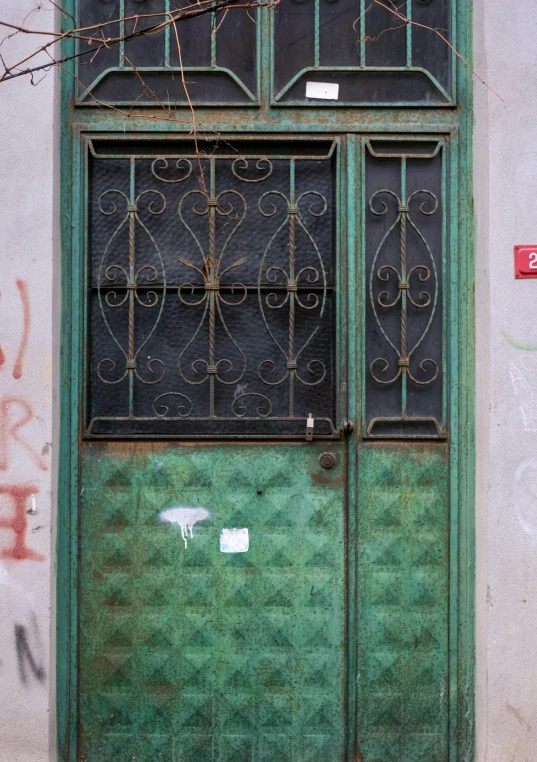 a large green door with iron bars on the top