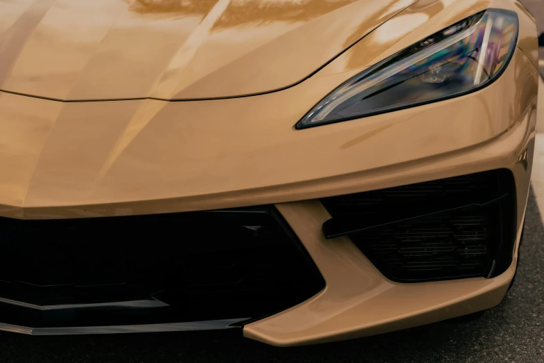 a close - up view of the front fender, grille and grille of a gold sports car
