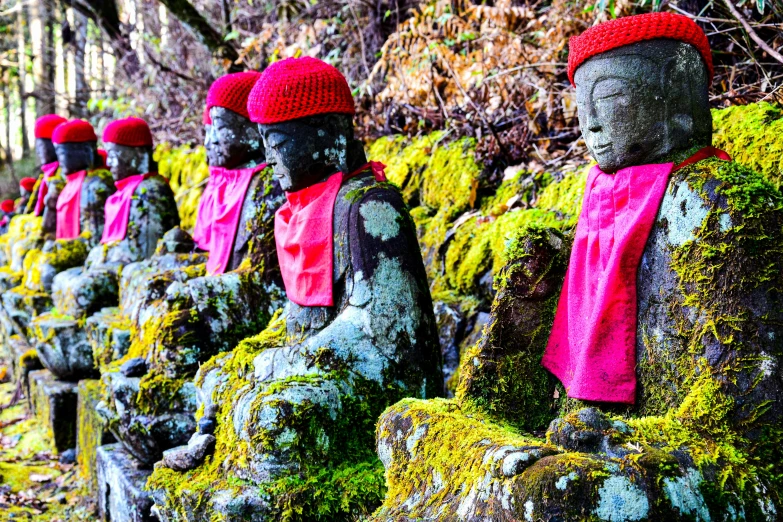 stone statues with red hats and red scarves