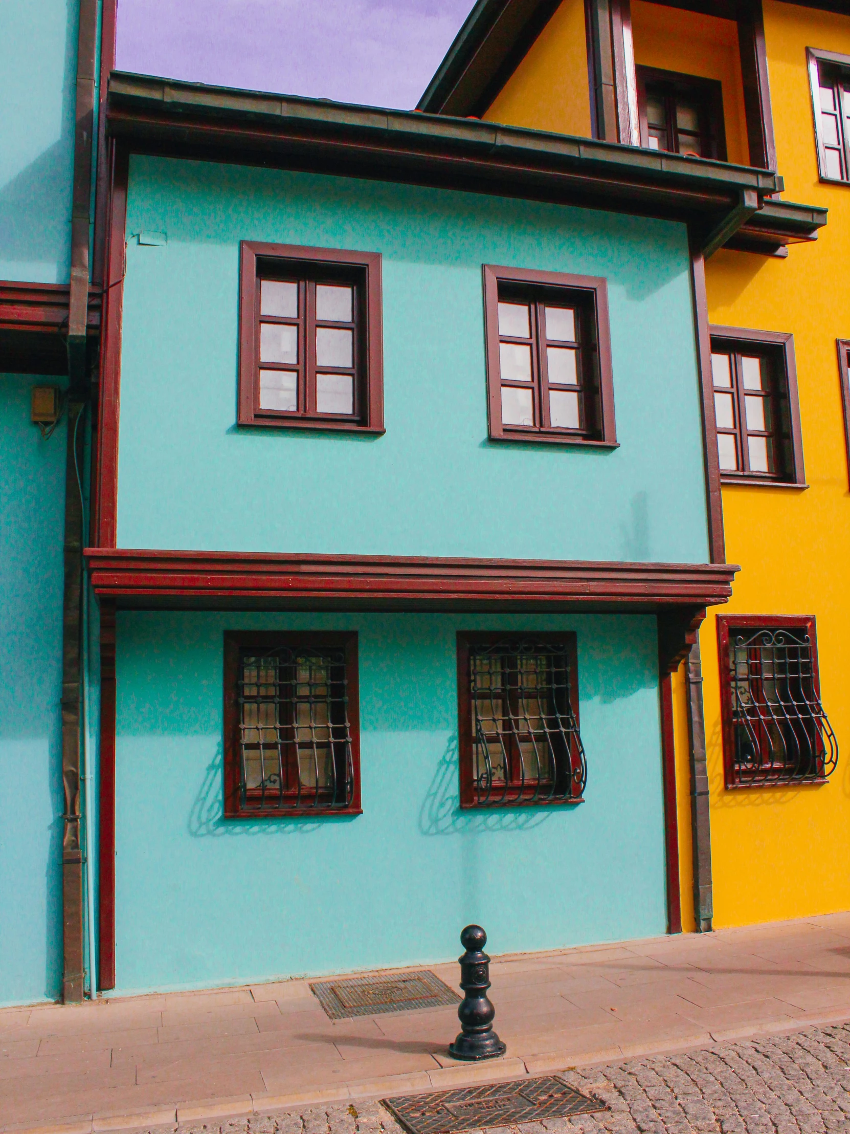 a blue, yellow and red building in front of another orange building