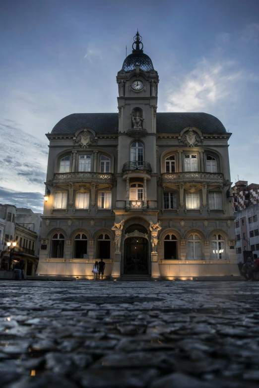 a large building with lights in the front and a clock