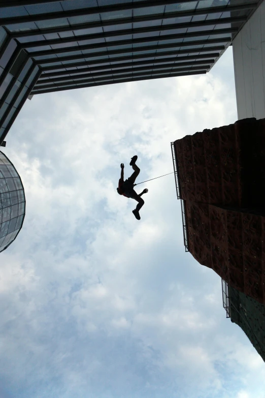 a man doing tricks on a rope high up in the air