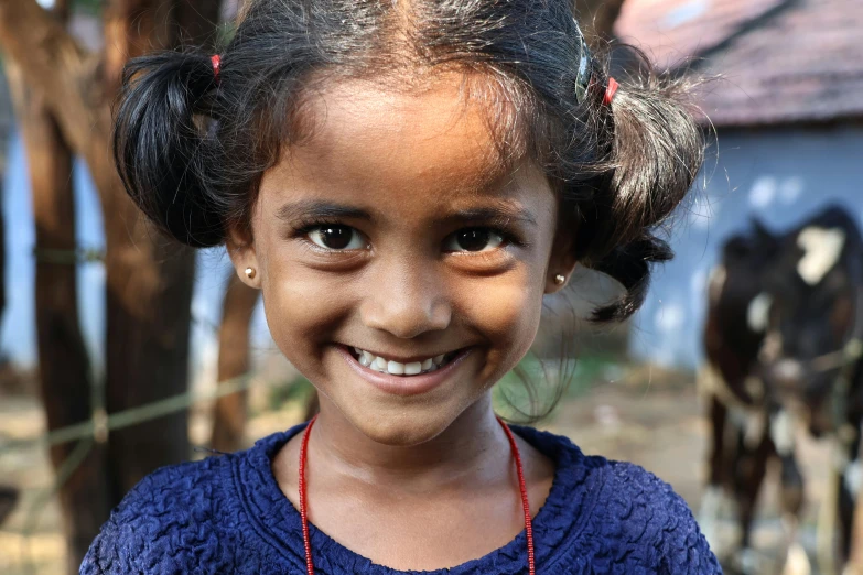 the  smiles at the camera with her cow behind