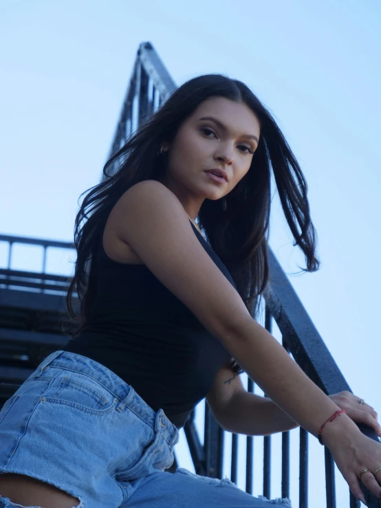 an attractive woman sitting on top of a metal rail