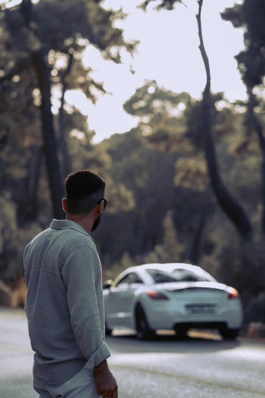 a man on a street with cars in the background