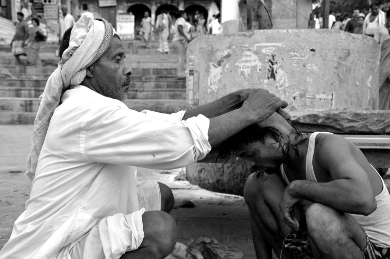 the man is putting the hair of another man