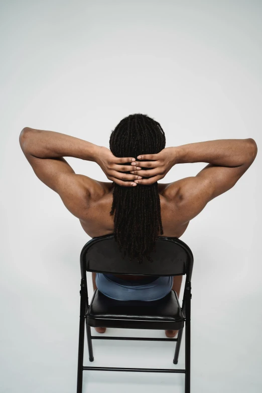 a woman sitting in a chair and holding her back