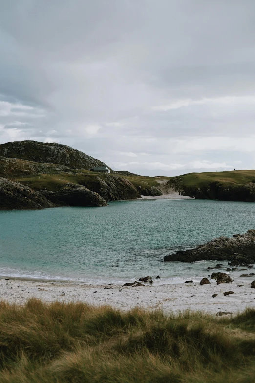 there are two hills overlooking the ocean and the sand