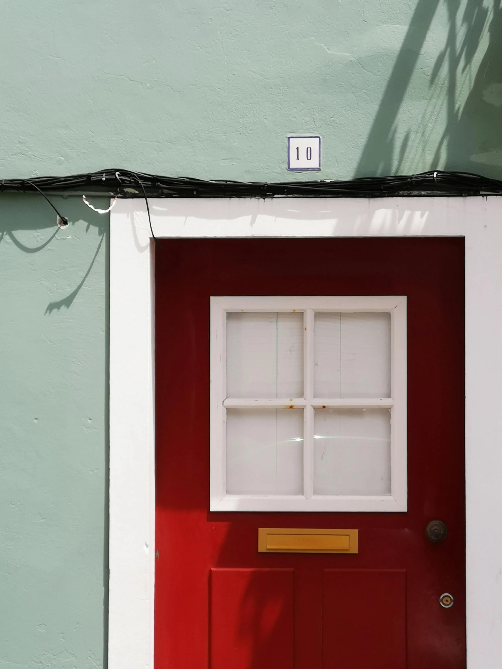 a green wall and red door with windows