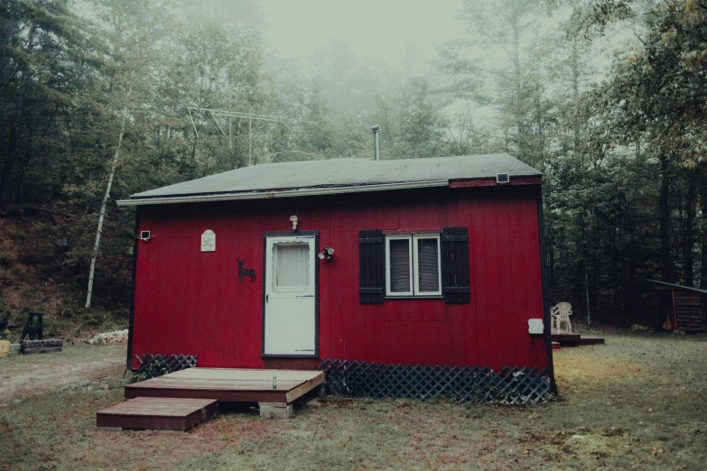 a red house sitting on top of a lush green forest