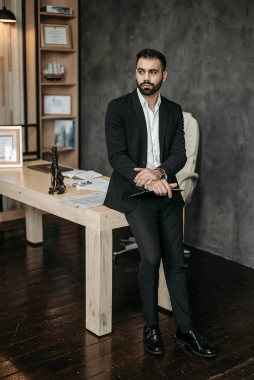 an indian american businessman seated at a wooden table