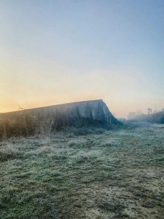 an empty grass field is seen at sunset