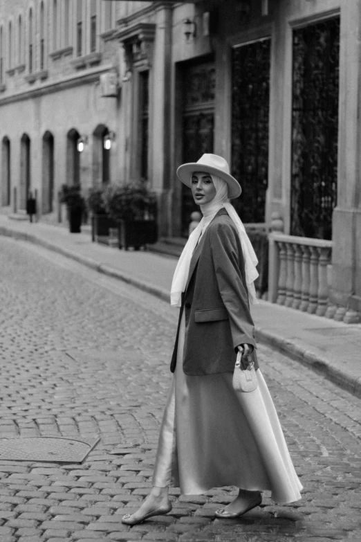 black and white pograph of woman in hat and trench coat