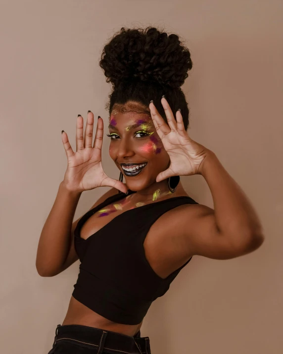 a beautiful young woman in a top making her face painted with her hands