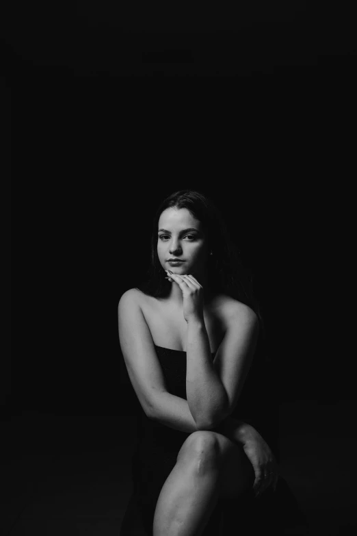 a woman sitting on top of a black floor