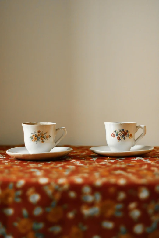 there are two cups and saucers on the table