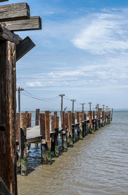 this is a pier on the beach with lots of posts