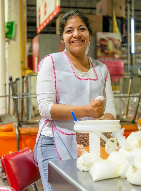 the smiling woman smiles as she places soing in a container