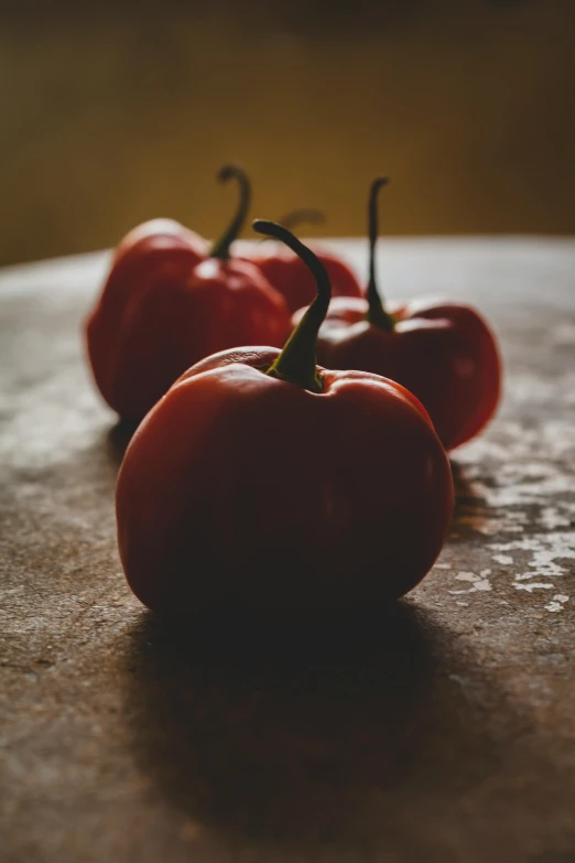 five red bell peppers sitting on top of a table