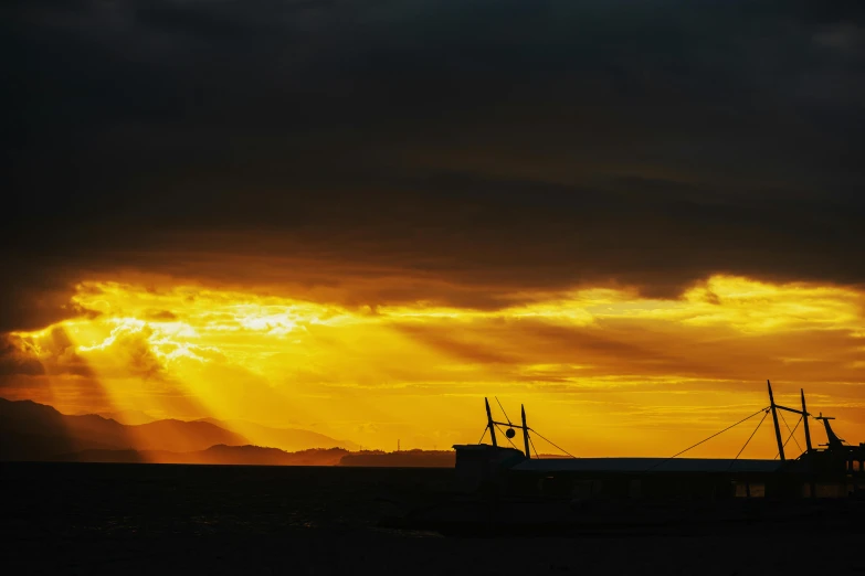 the sun shines through clouds while the boat floats in the water