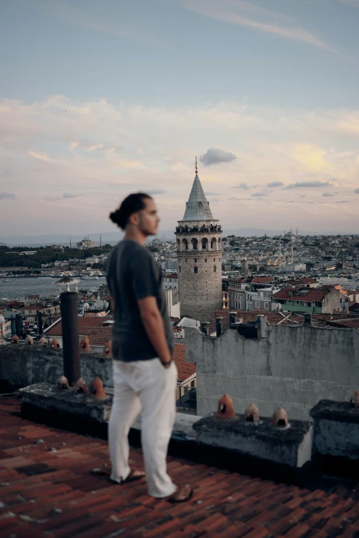 a man standing on the roof looking out at the city