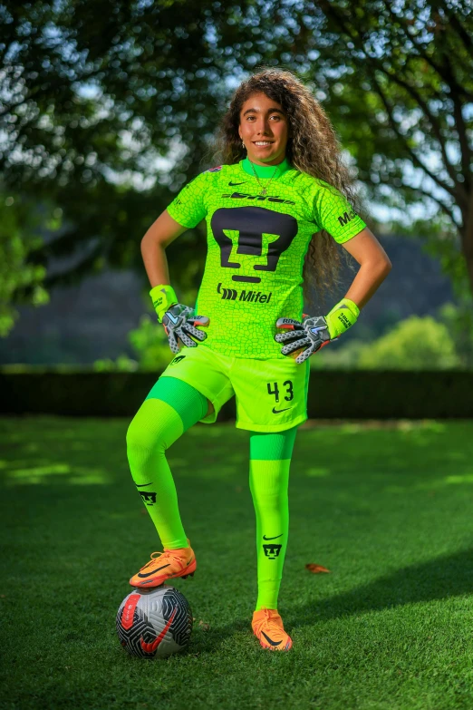 a woman is posing on the soccer field in green