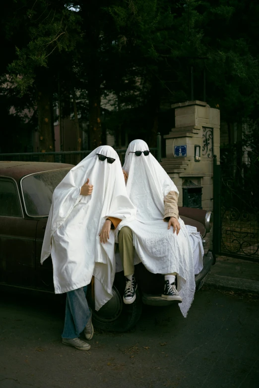 two men covering their heads from the wind in a dark town