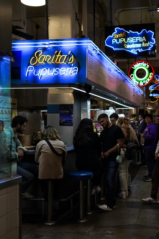 a group of people that are standing near some food